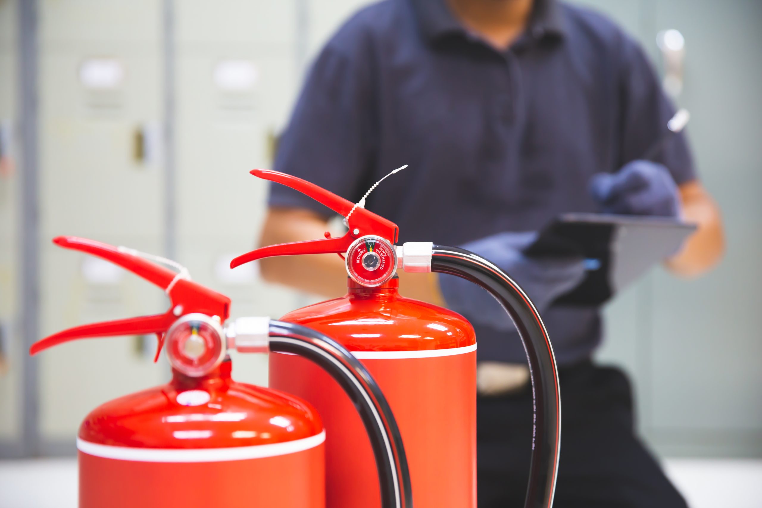 Fire extinguishers being inspected and tested by a professional